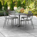 A Lancaster Table & Seating outdoor patio table with chairs and a grey umbrella.