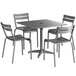 A Lancaster Table & Seating matte gray aluminum dining table with chairs set around it.