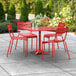 A red Lancaster Table & Seating outdoor table and chairs set on a concrete patio.