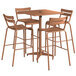 A brown Lancaster Table & Seating bar height outdoor table with 4 barstools.
