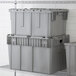 A stack of Lavex gray industrial storage totes.