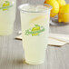 A clear plastic cup filled with ice-cold lemonade.