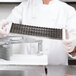 A person in a white coat holding Nemco 3/16" scalloped blade assembly.