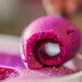 A person uses a spoon to scoop purple Pitaya Foods sorbet.