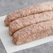 Warrington Farm Meats Green Pepper and Onion Sausage Links on a white surface.