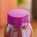 A purple plastic bottle with a violet tamper-evident cap on it.