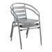 A Lancaster Table & Seating silver metal outdoor arm chair with a metal frame.