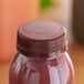 A plastic bottle of juice with a brown tamper-evident cap.