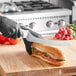 A person in black gloves using a Choice bread knife to cut a sandwich.