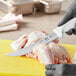 A person using a Choice 8" Breaking Knife to cut up a chicken.