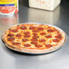 An American Metalcraft heavy weight aluminum pizza pan with a pepperoni pizza.