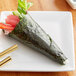 Half Sheet Blue Seaweed Sushi Nori on a table with a sushi roll and chopsticks.