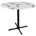A white marble round table top with a black cross base.