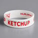 A white rubber wristband with red text that says "Ketchup"