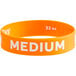 An orange silicone wristband with white text that says "Medium"