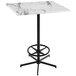 A white marble Holland Bar Table with a black foot rest base.