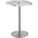 A Holland Bar Stool white marble round bar height table with stainless steel round base.