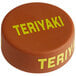 A brown circular silicone lid with yellow text that reads "Teriyaki"