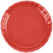 A close-up of a red fluted quiche dish with a scalloped edge.