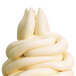 A white swirl of soft serve ice cream in a cone from a Carpigiani soft serve machine.