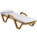 A Lancaster Table & Seating sand chaise lounge with white cushion and pillow.