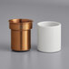 A white cylinder with a copper top.