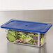 A Carlisle 1/4 size plastic food pan lid with blue Smart Lid on a container of lettuce.