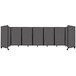 A Versare charcoal gray room divider with multiple panels and four legs.