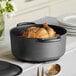 A Valor pre-seasoned cast iron dutch oven with a chicken inside.