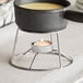 A Valor stainless steel fondue pot on a stand with a candle