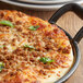 Beyond Meat Italian sausage crumbles on a pizza in a pan.