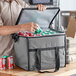 A man putting a can into a Choice gray insulated cooler bag.