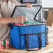 A man putting blue and white cans into a Choice blue insulated cooler bag.