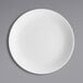A Fortessa Caldera bright white china plate on a gray surface.