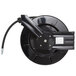 A black Equip by T&S metal hose reel with a black hose attached.