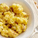 A bowl of roasted cauliflower seasoned with Goya Adobo All-Purpose Seasoning with Pepper.