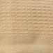 A close-up of a beige woven cotton blanket with a honeycomb pattern.