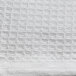 A close up of a white knitted fabric with a honeycomb pattern.