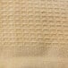 A close-up of a beige woven fabric with a honeycomb pattern.