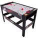A black and red air hockey table with red handles on a Triumph 4-in-1 game table.