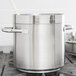 A close-up of a large silver Vollrath stainless steel stock pot.