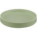 A round green Cal-Mil Hudson melamine plate with a raised rim.