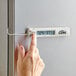 A person using a CDN digital refrigerator thermometer to check the temperature of a refrigerator.