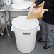 A man pouring rice into a white Continental ingredient storage bin.