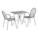 A Lancaster Table & Seating Harbor Gray rectangular outdoor table with ornate legs and 2 arm chairs.