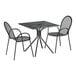 A Lancaster Table & Seating Harbor black metal table with two chairs on an outdoor patio.