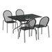 A black Lancaster Table & Seating rectangular outdoor table with modern legs and four black chairs.