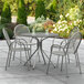 A Lancaster Table & Seating Harbor Gray outdoor table with 4 chairs on a patio.