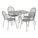 A Lancaster Table & Seating Harbor Gray metal table with wire mesh top and ornate legs with 4 arm chairs.