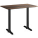 A Lancaster Table & Seating rectangular counter height table with a dark wood top and black legs.